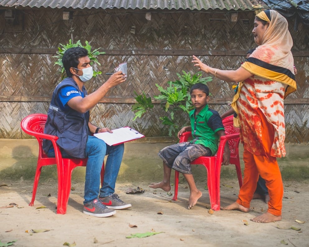Mazhar inspecting the medicine taken by Halima, 25, who with her son recovered from diphtheria