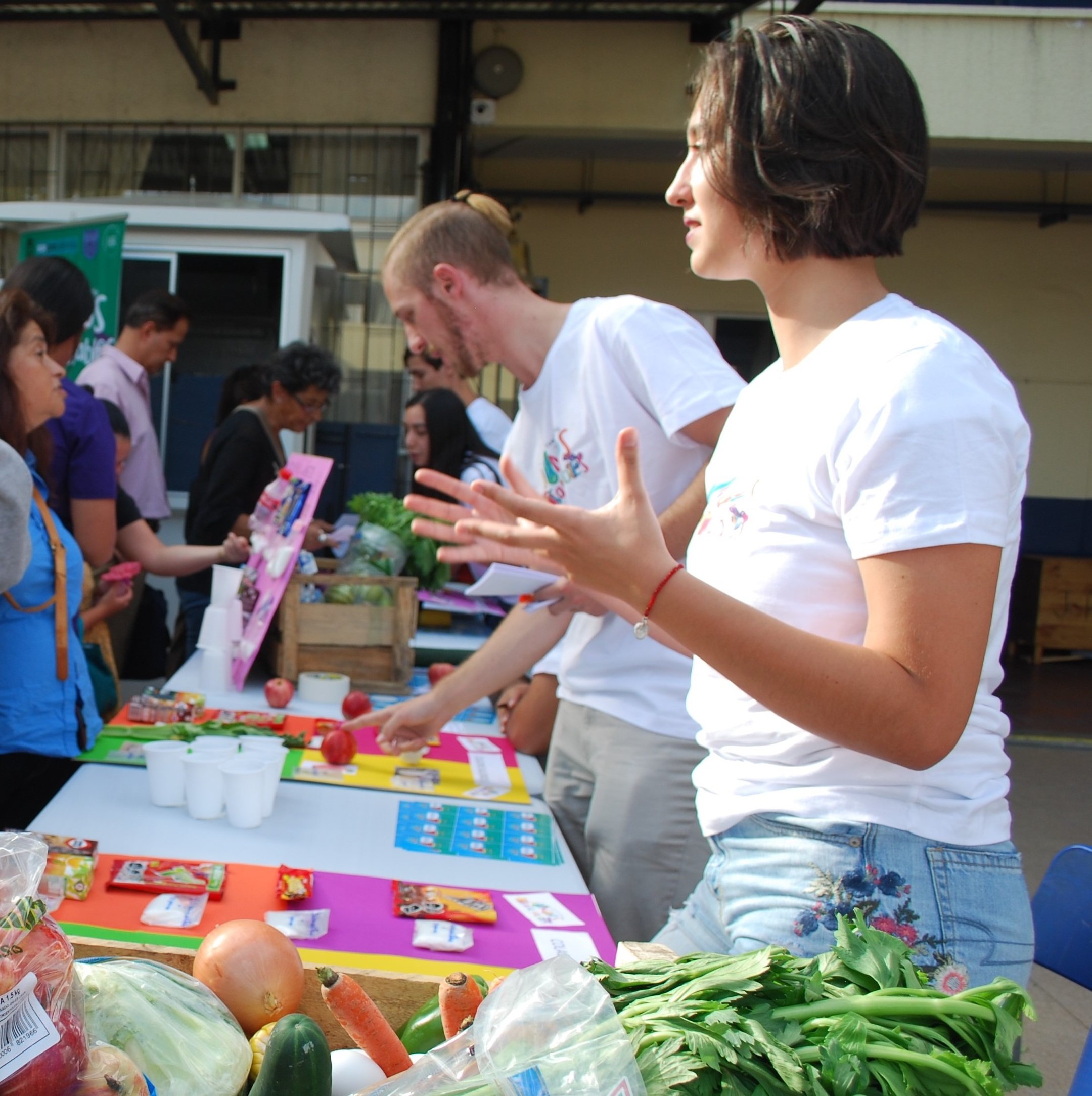 group of people looking at various vegetables on a table