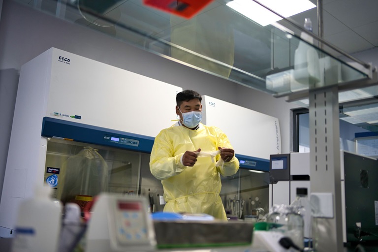 A doctor puts on his gloves inside a laboratory